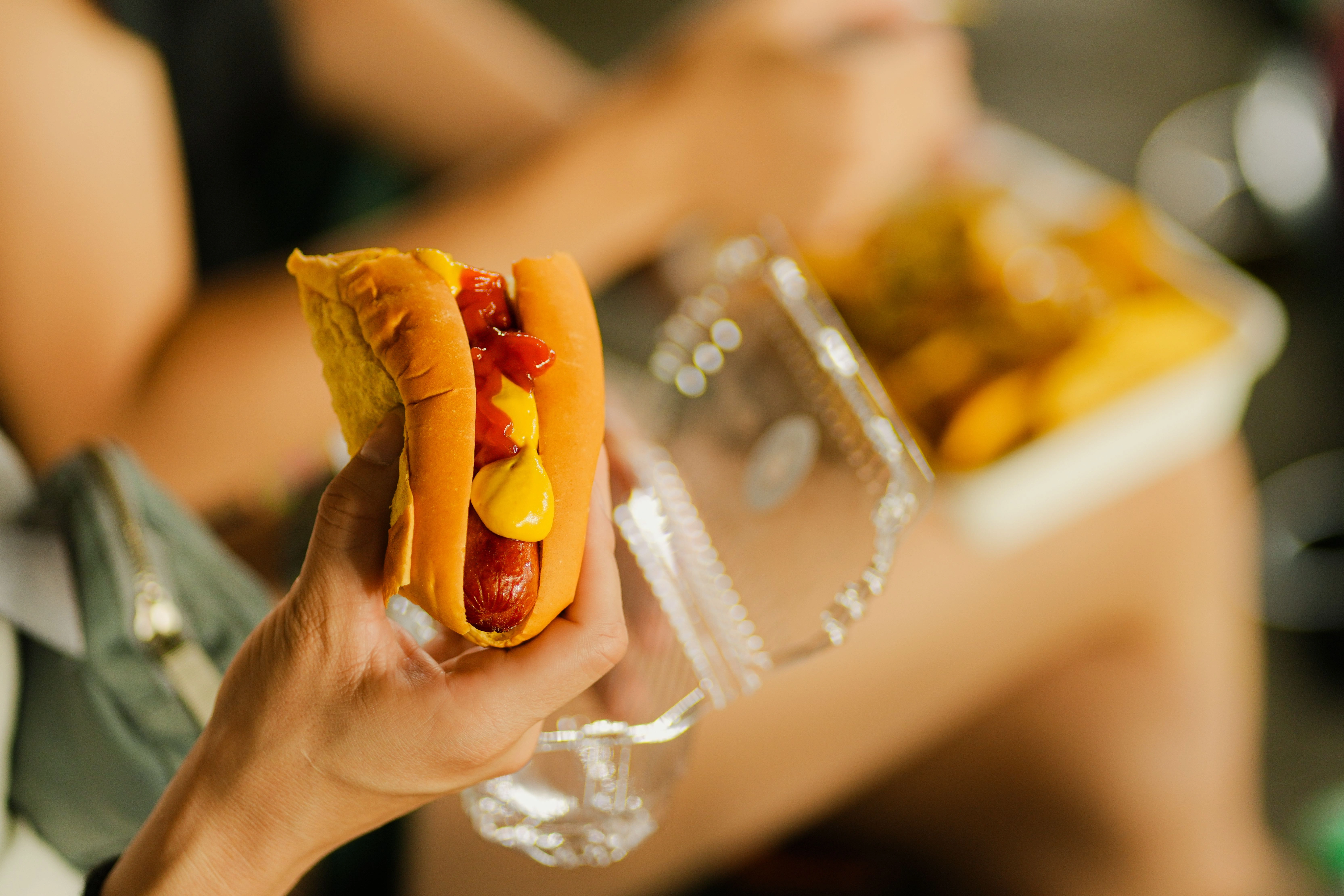 Eating an ultra-processed hot dog – a symbol of industrial food that feeds the body but does not nourish it and contributes to fatigue and a foggy mind