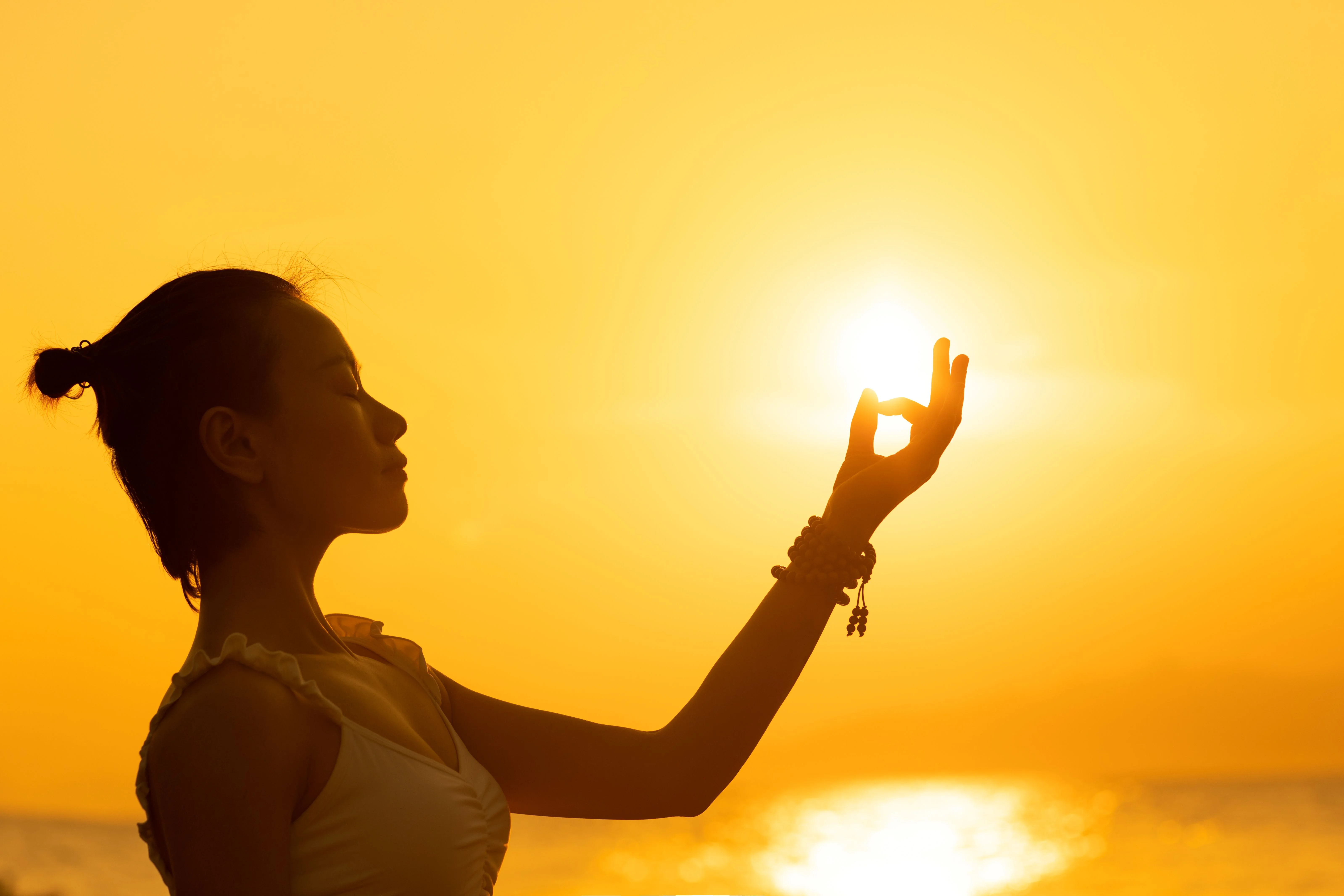 Silueta člověka v meditaci při západu slunce – symbol propojení těla, mysli a duše